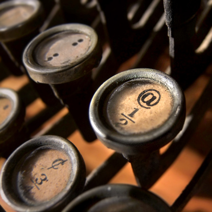 Close-up on the @ key on a typewriter keyboard. 