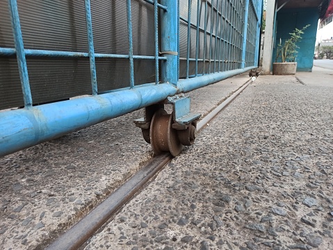 close up rusty steel roller wheel on steel sliding gate