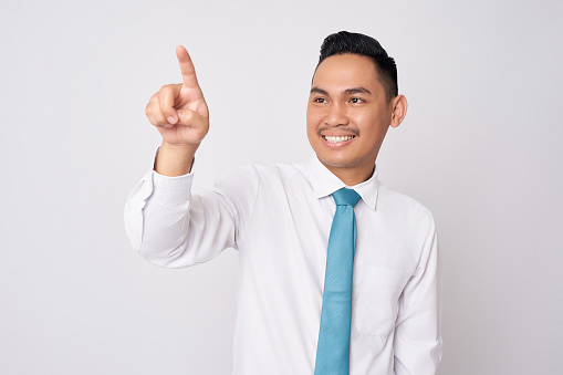 Young Asian businessman wearing a formal shirt and tie hand touching a virtual screen isolated on white background