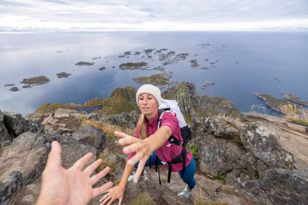 istock Hiker helping teammate to reach mountain top, summit 1746241351