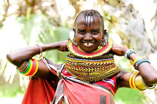 "A Turcana tribeswoman in traditional beadwork. Lake Turcana, Kenya.The Turkana are Kenya's third-largest tribe and the second largest group of nomadic pastoralists (after Maasai). The majority live in Turkana District of Rift Valley in the arid northwest of Kenya. Most of Turkana are cattle herders, some engage in small-scale agriculture and fishing on Lake Turkana. They speak Turkana which is similar to the Maasai language and is considered to be of Nilotic in origin.Traditional dress and ornaments are of vital importance, much emphasis being placed on adornment of both women and young Morani (warrior). Beads and jewelry indicate a woman's wealth and marital status. The traditional hairstyle for a woman is a braided Mohawk."