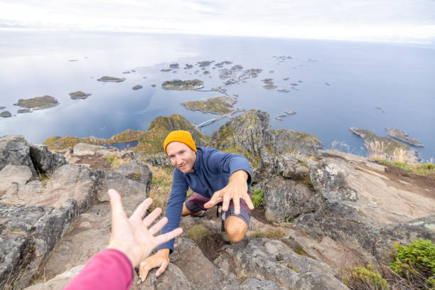istock Hiker helping teammate to reach mountain top, summit 1746244774