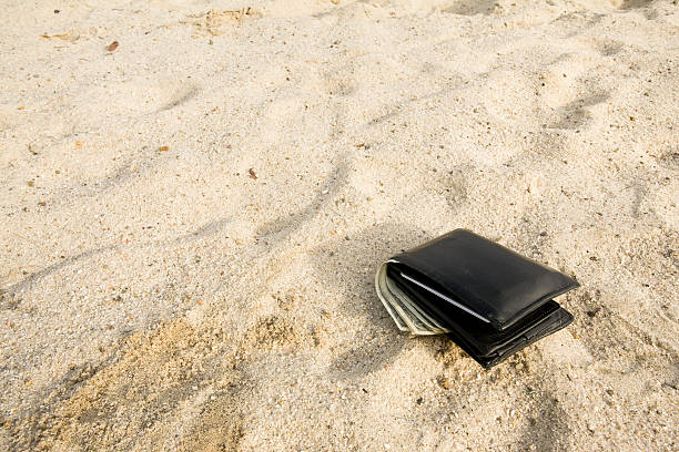 billetera perdido en la arena de la playa - lost beach fotografías e imágenes de stock