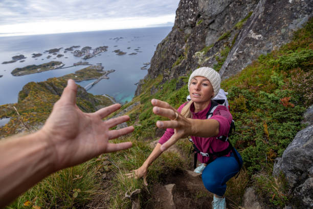 istock Hiker helping teammate to reach mountain top, summit 1746249159