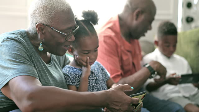 Black seniors and grandkids enjoying leisure with technology