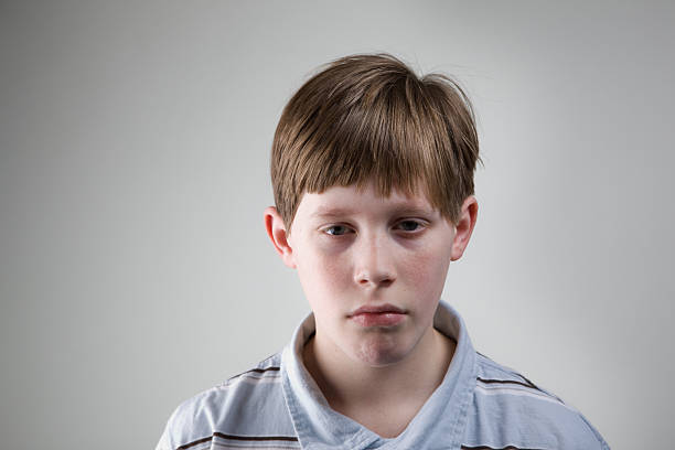 Serious young teenage boy on a white background.
