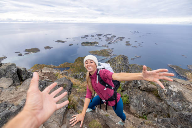 istock Hiker helping teammate to reach mountain top, summit 1746252089