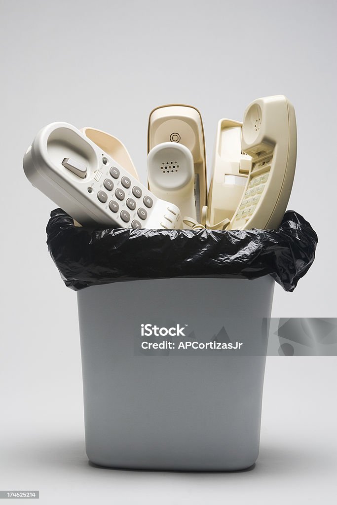 Telefoni fissi in un cestino dei rifiuti - Foto stock royalty-free di Cavo telefonico