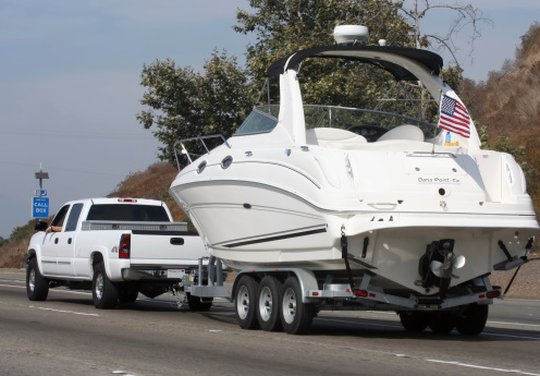 Pick-up truck tows large recreational water craft