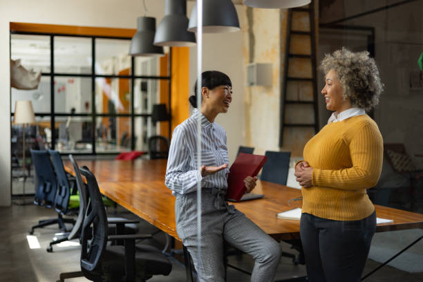 istock Happy female colleagues talking in the office. 1746257021