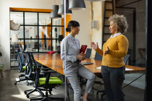 Happy female entrepreneurs talking in the office.