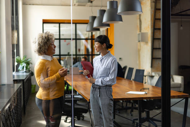 istock Smiling colleagues talking while working in a business office. 1746257619