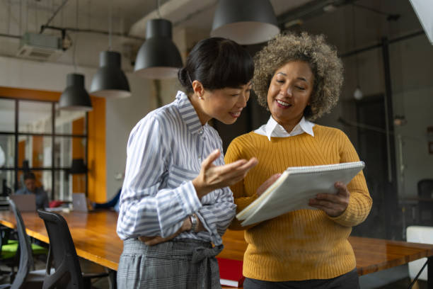 istock Happy female managers reading reports in the office. 1746259396