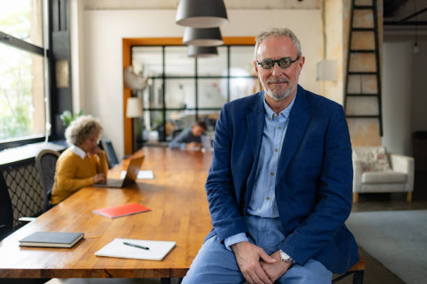 istock Mature CEO sitting on a desk in the office. 1746260583