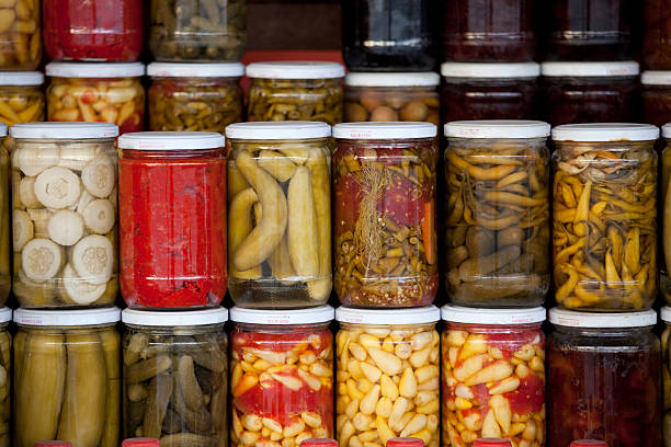 Assortment of glass jars filled with pickled vegetables stock photo