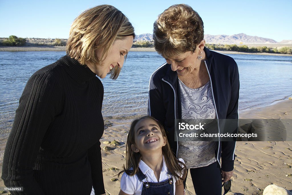 Single Parent Teamwork mother and grandmother look down at daughter with love Active Seniors Stock Photo