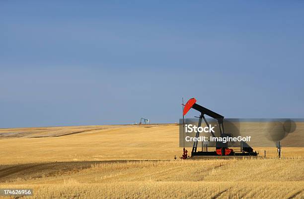 Foto de Red Pumpjack Em Dos Campos Petrolíferos No Texas e mais fotos de stock de Alberta - Alberta, Cor Preta, Pradaria