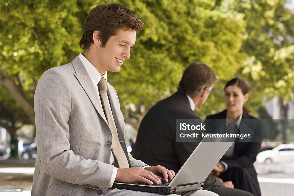 Souriant jeune homme d'affaires travaillant sur un ordinateur portable - Photo de 20-24 ans libre de droits