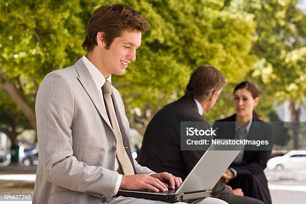 Photo libre de droit de Souriant Jeune Homme Daffaires Travaillant Sur Un Ordinateur Portable banque d'images et plus d'images libres de droit de 20-24 ans