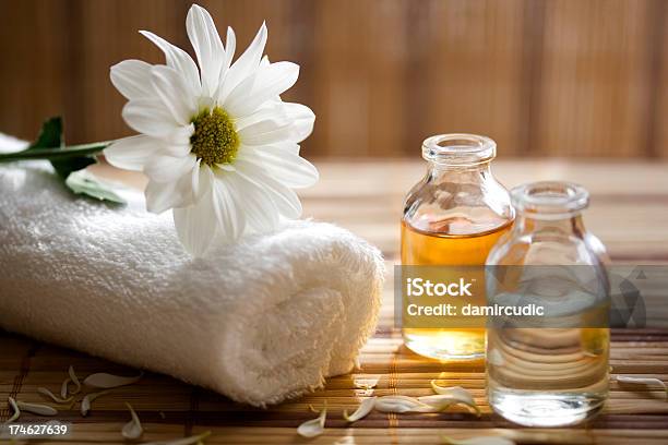 Aroma Therapy Oils Placed Next To A White Towel And Flower Stock Photo - Download Image Now