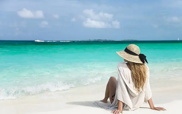 woman sitting on the shoreline at the beautiful beach