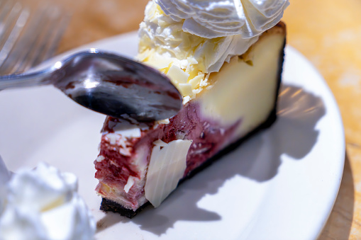 Cherry Cheesecake on a plate with squirty cream.