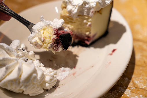 Cherry Cheesecake on a plate with squirty cream.