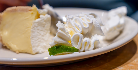 Lime Cheesecake on a plate with squirty cream.