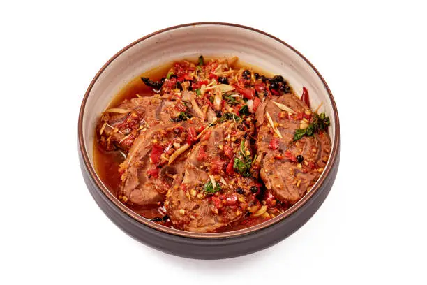 Photo of Stir-fried spicy beef with fingerroot and black pepper on black-white plate isolated on white background.