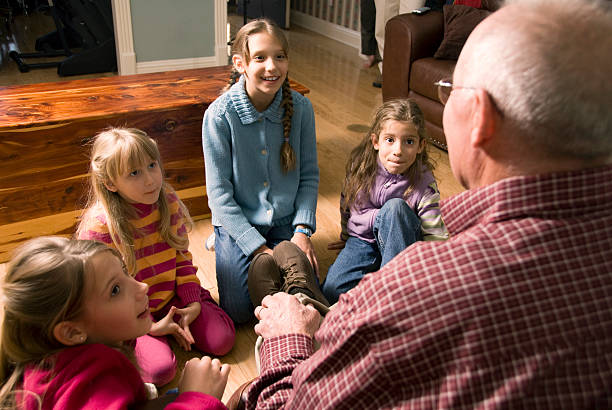 Grandfather telling a story to Grandchildren Little girls listening to their grandfather.More in this series can be found here: bedtime photos stock pictures, royalty-free photos & images