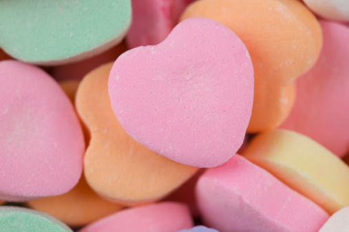 Macro studio image of heart shaped candy with main candy in center with room for copy.
