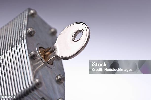 Key Inserted In Keyhole Of A Lock Against Isolated Background Stock Photo - Download Image Now