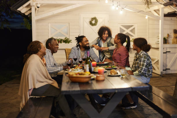 istock Happy black extended family having dinner at picnic table by night. 1746292057