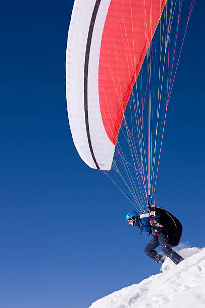 istock Paraglider taking off from snowy slope 174629653