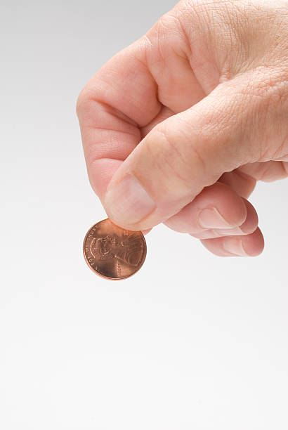 рука держа penny - penny coin human finger human thumb стоковые фото и изображения