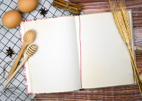 Recipe book on the wooden kitchen table. Close-up. Copy space. Top view.