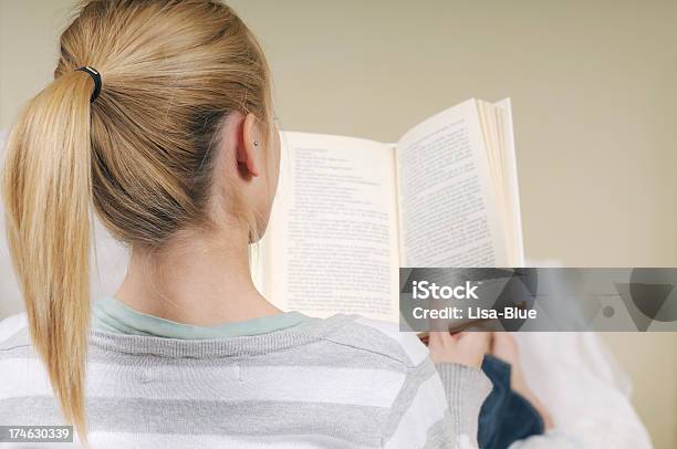 Rubia Adolescente Estudiando En El Sofá En La Sala De Estar Foto de stock y más banco de imágenes de Vista posterior