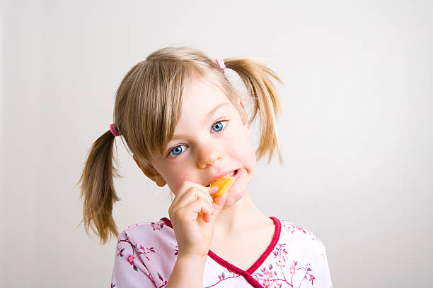 istock Young girl biting into a slice of cheese 174630379