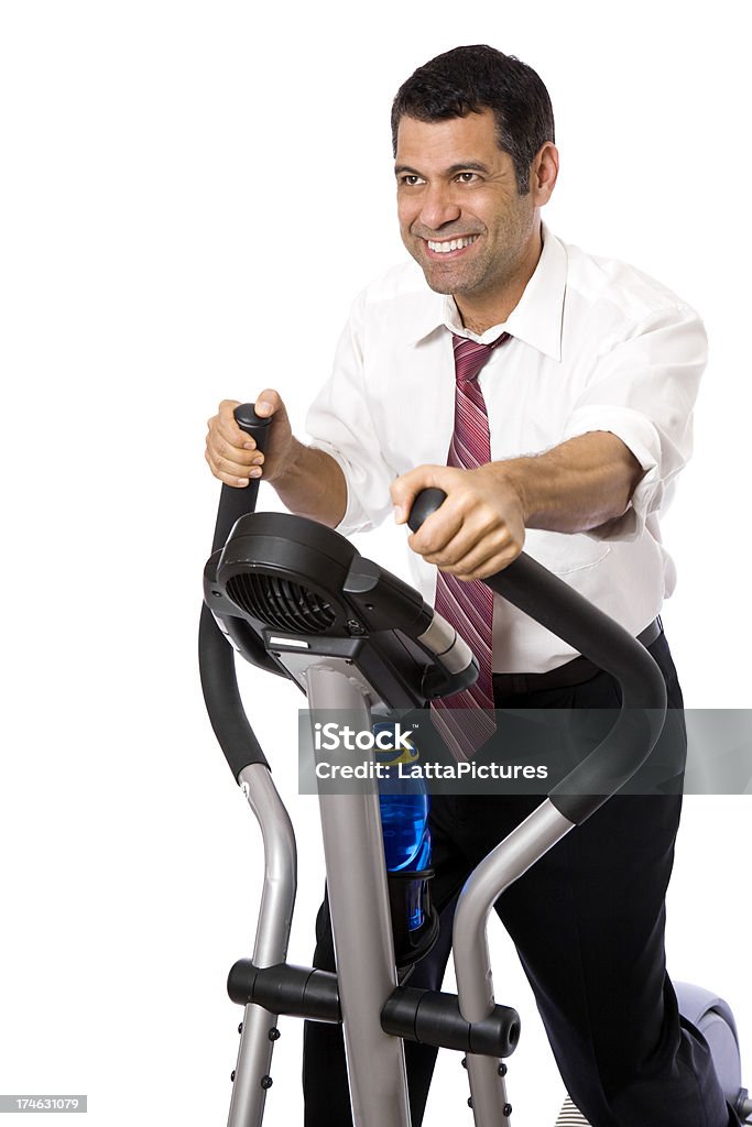 Man wearing shirt and tie on elliptical exercising "man in shirt and tie on cross trainer, isolated on white background" Cross Trainer Stock Photo