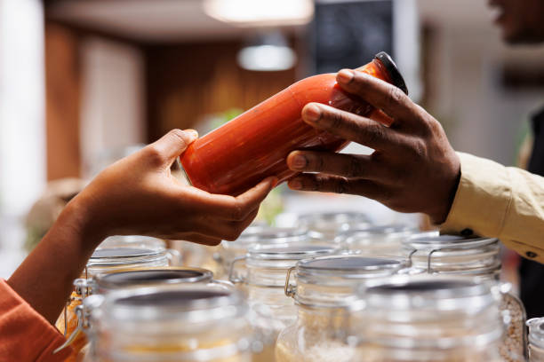 Two hands hold a bottle of pasta sauce