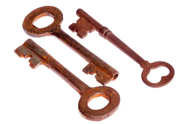Three rusty antique keys isolated on white.