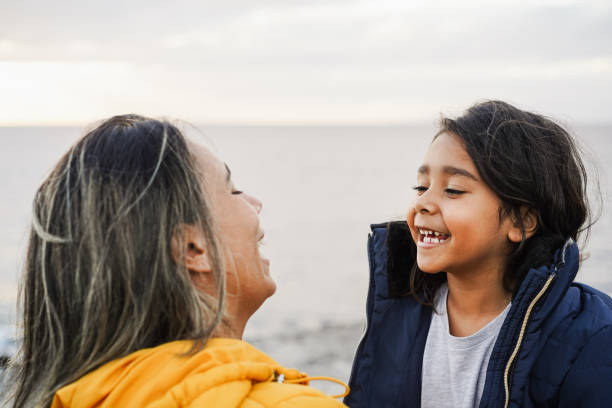 happy latin mother and daughter having fun together during winter time - mom day concept - focus on kid face - life events laughing women latin american and hispanic ethnicity imagens e fotografias de stock