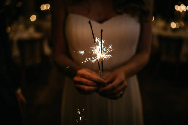Roung woman is holding a lit miracle candle during party