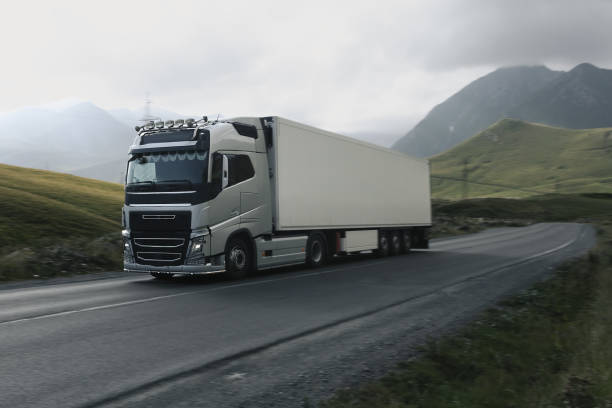 istock semi truck driving through mountain road pass 1746337176