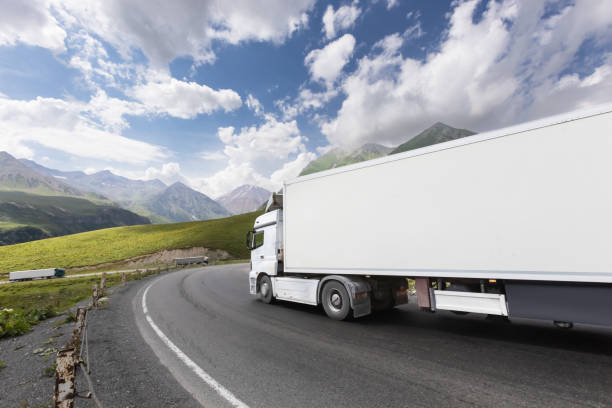 istock semi truck driving through mountain road pass 1746338389
