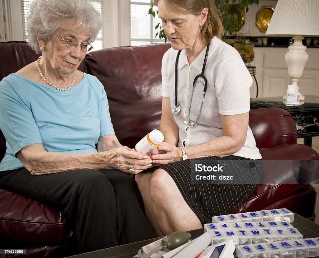 Su profesional de atención médica y sanitaria ayuda a senior mujer con el medicamento - Foto de stock de 50-59 años libre de derechos