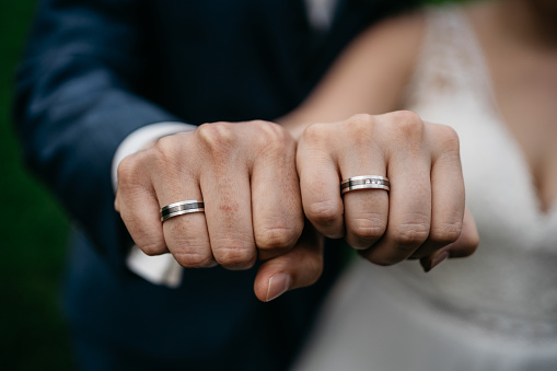 bridal couple showing rings by making a fist