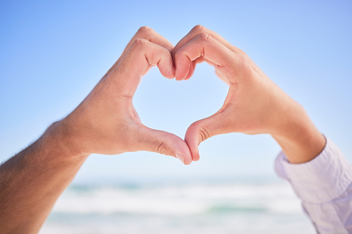 Love, hands or couple at beach with heart sign on holiday vacation or romantic honeymoon to celebrate marriage Commitment, trust or lovers showing hearty shape emoji or icon in fun summer romance