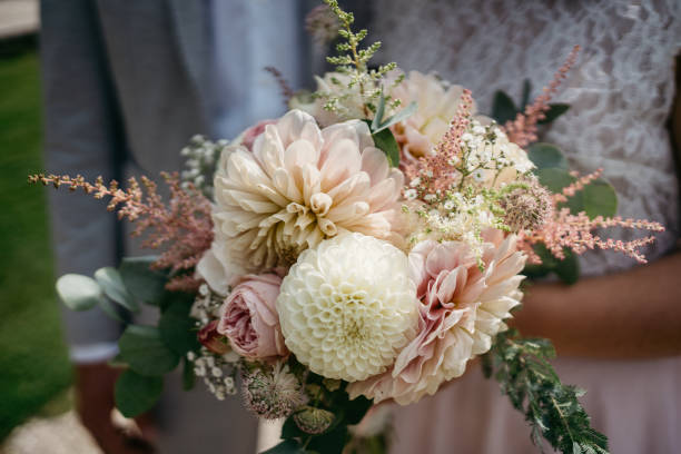 istock bride holding her wedding flowers with rose colored roses 1746347619