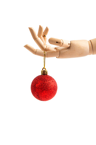 Wooden hand holding Christmas ball isolated on white background